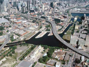 Vue aérienne de l'autoroute Bonaventure et du canal Lachine avec le centre-ville de Montréal en arrière-plan